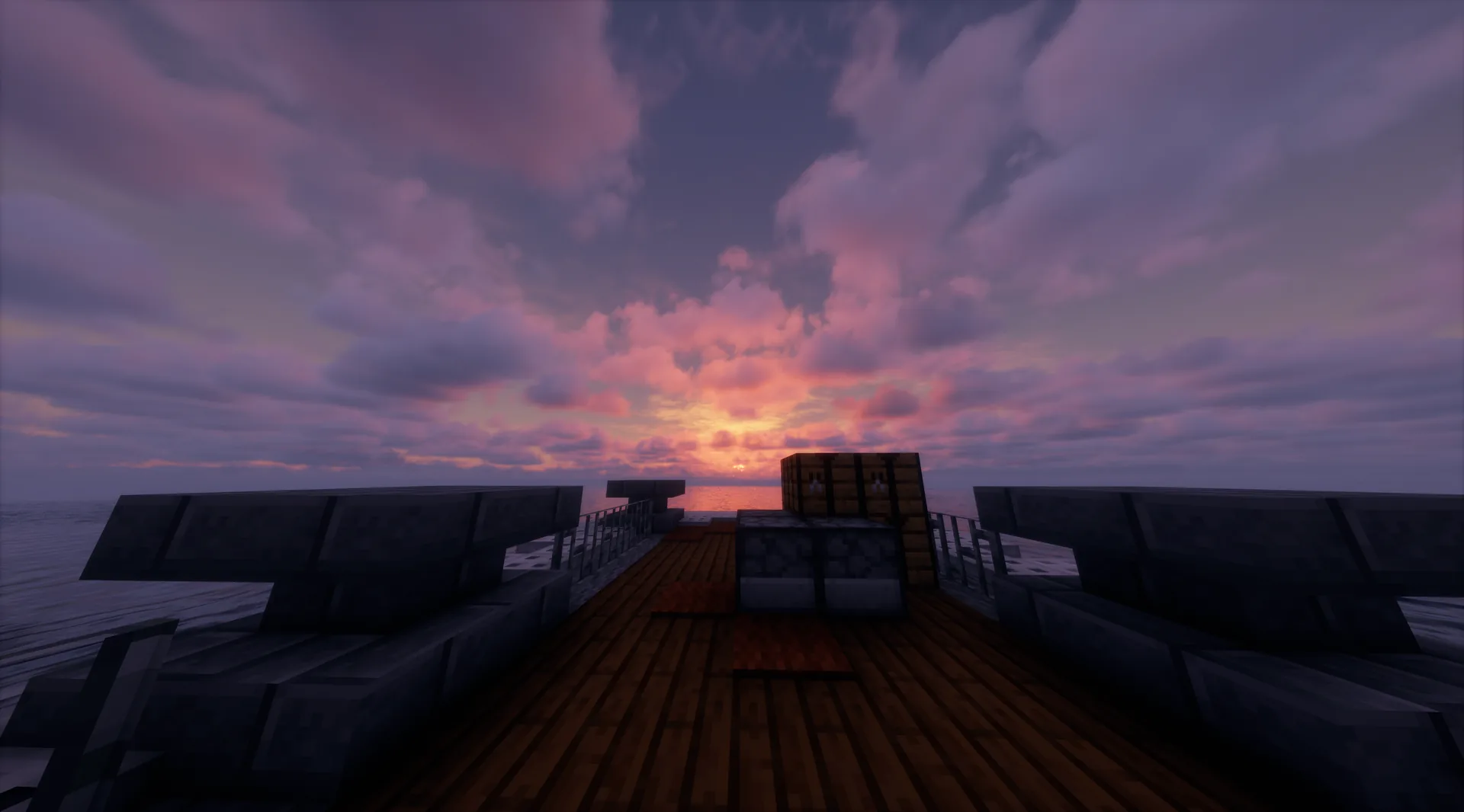 Cubierta de madera de un barco al amanecer con el cielo teñido de rosa y naranja